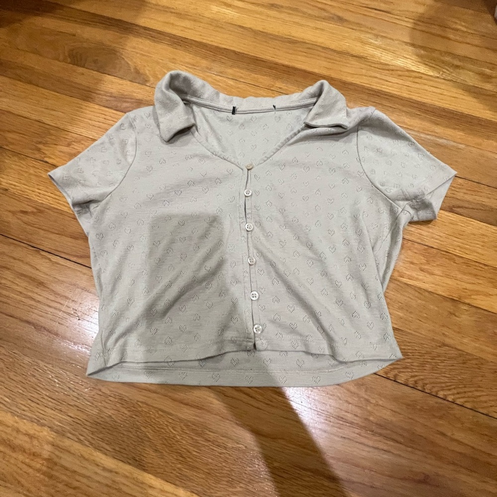 Beige top with buttons running down the middle and a collar